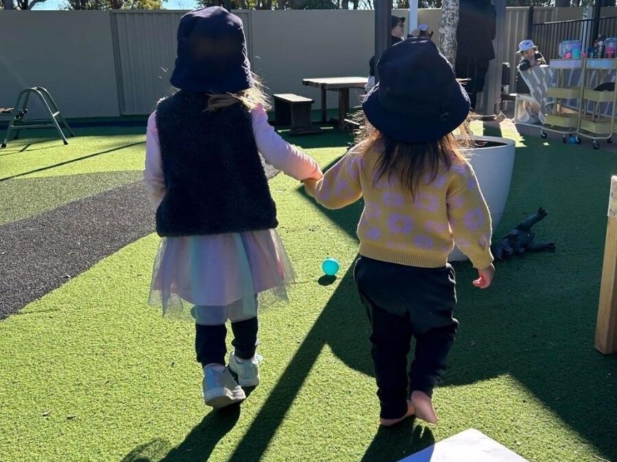 Friends holding hands in the Enrich playground