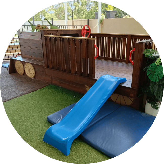 Wooden train play equipment in nursery and toddler playground