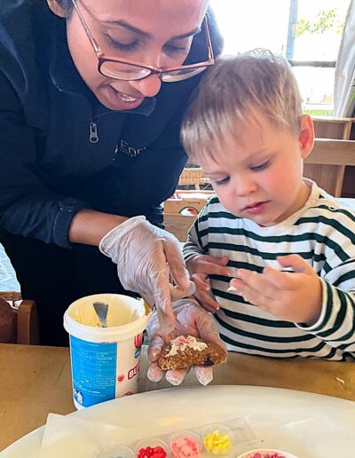 Decorating the cookies with edible flowers and sprinkles. A practical life skills experience for our toddlers.