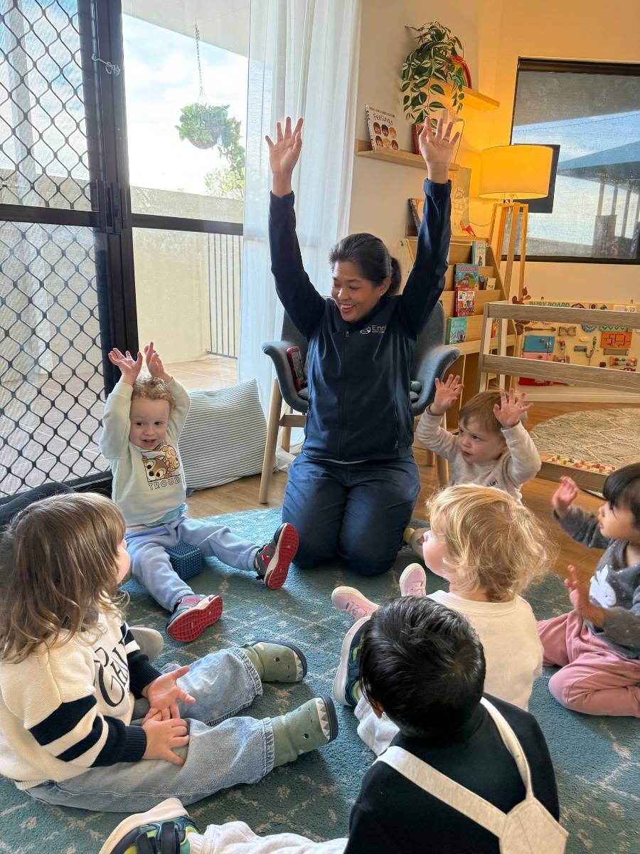 Toddler children enjoying mat time with their educator