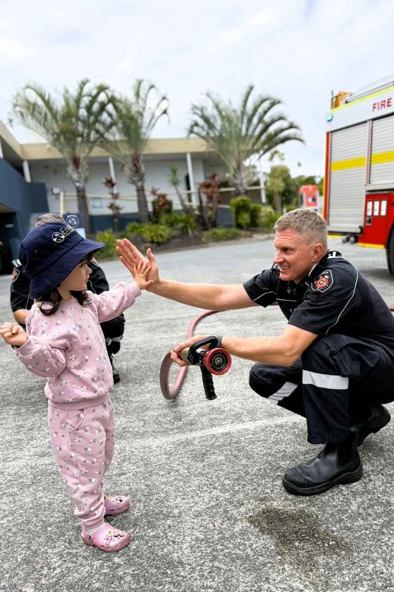 Child meeting Queensland firefighters during a fire truck visit at Enrich