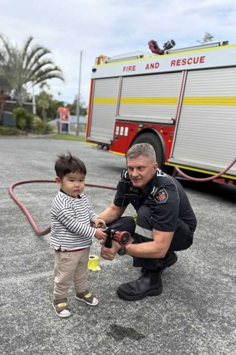Children holding a fire hose during a Queensland Fire Department visit to Enrich Early Education