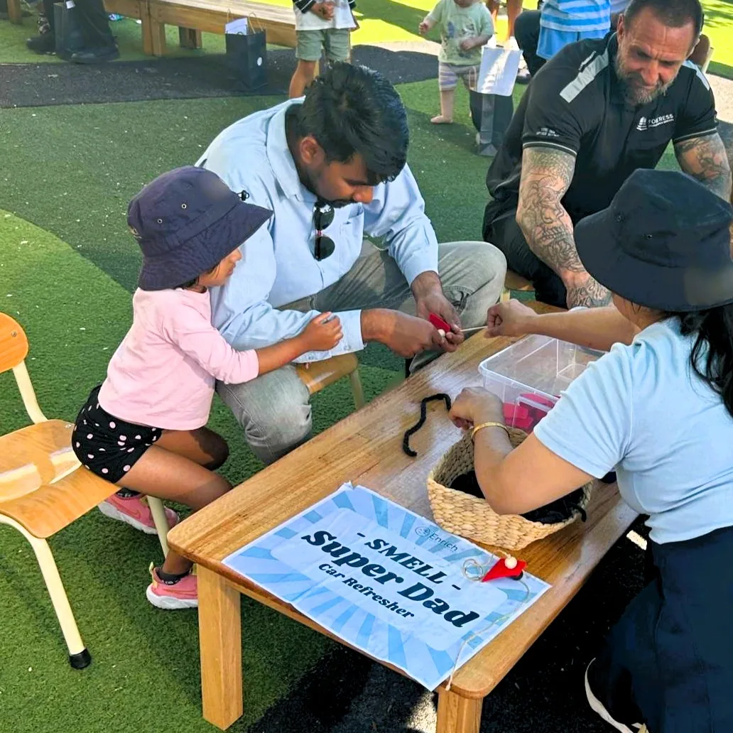 Dad and child making a Super Dad car air freshener during the Father's Day five-senses celebration at Enrich Early Education in Southport